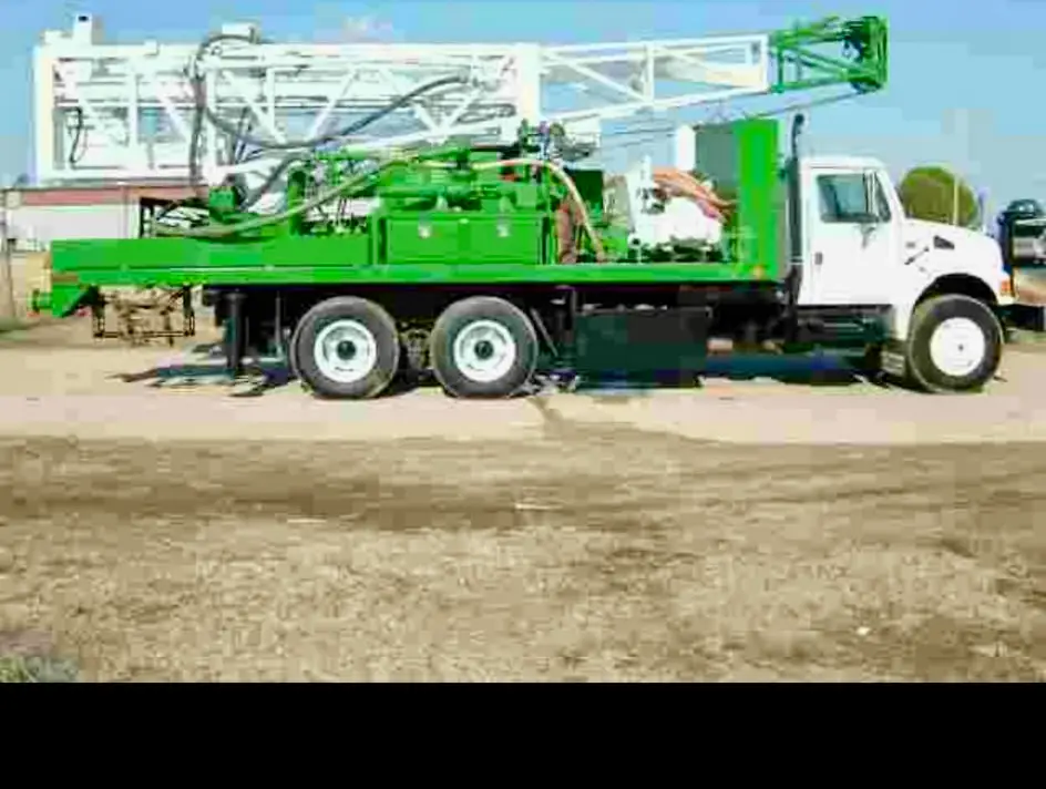 Water well drilling rig mast showing depth and reach